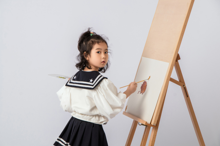 画板前努力画画的可爱女孩图版权图片下载