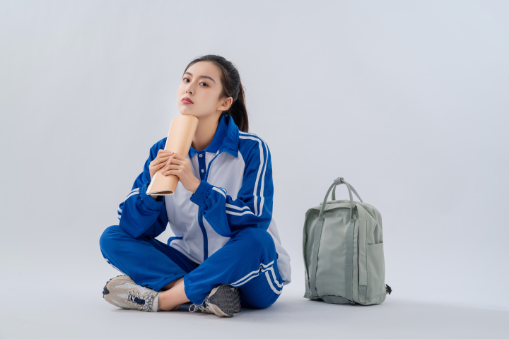 高中生手拿课本笔记抬头思考实拍图版权图片下载