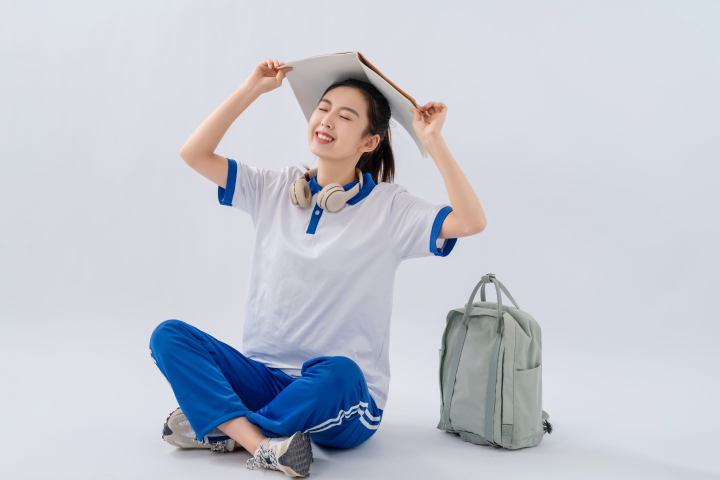 头顶课本俏皮可爱的高中生实拍图版权图片下载 头顶课本俏皮可爱的高中生实拍图版权图片下载