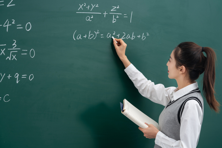 黑板上讲解数学题目的女教师版权图片下载 黑板上讲解数学题目的女教师版权图片下载
