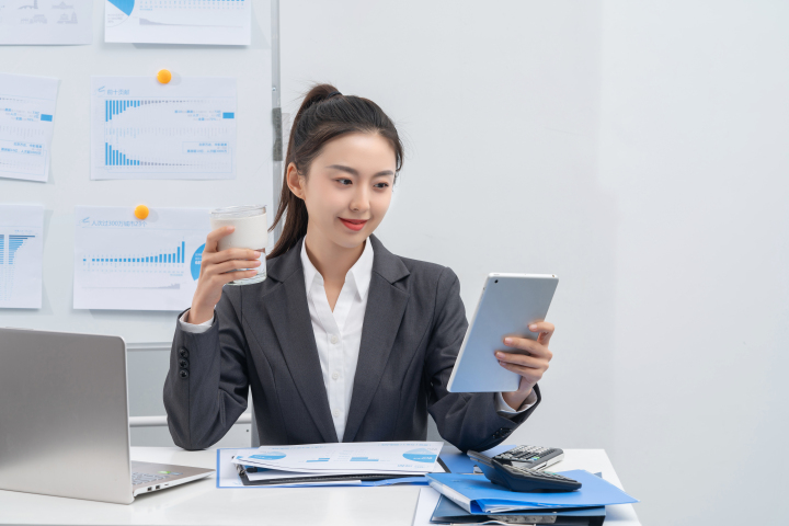 手握咖啡看数据的女白领实拍图版权图片下载 手握咖啡看数据的女白领实拍图版权图片下载