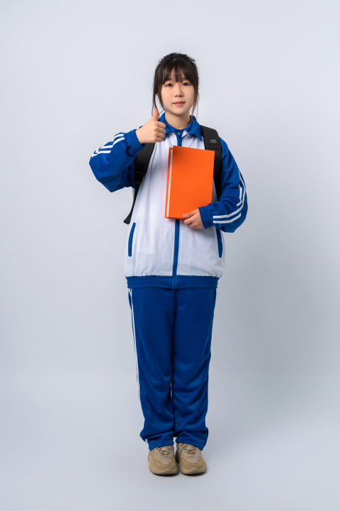 拿着本子站着的女学生实拍图版权图片下载 拿着本子站着的女学生实拍图版权图片下载
