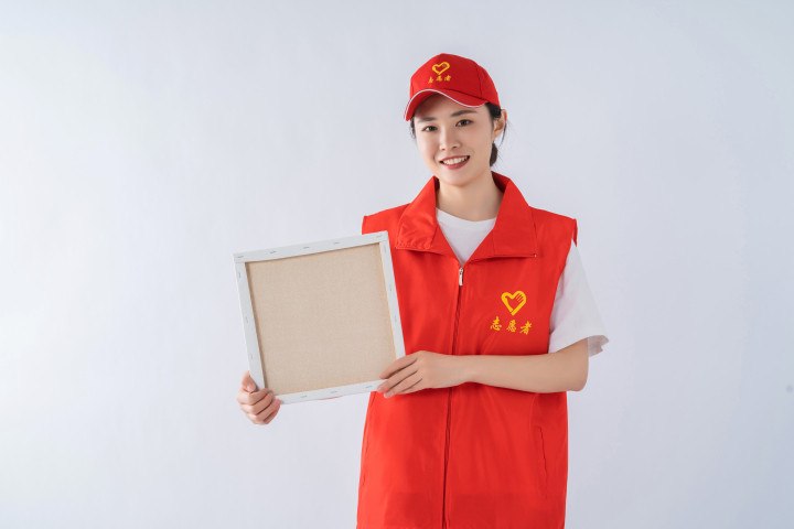 拿着板子热情服务的志愿者实拍图版权图片下载