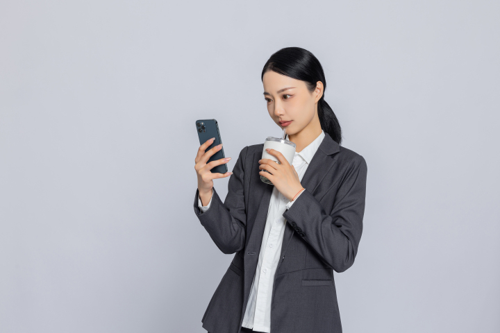 职业女性喝咖啡看手机实拍图版权图片下载
