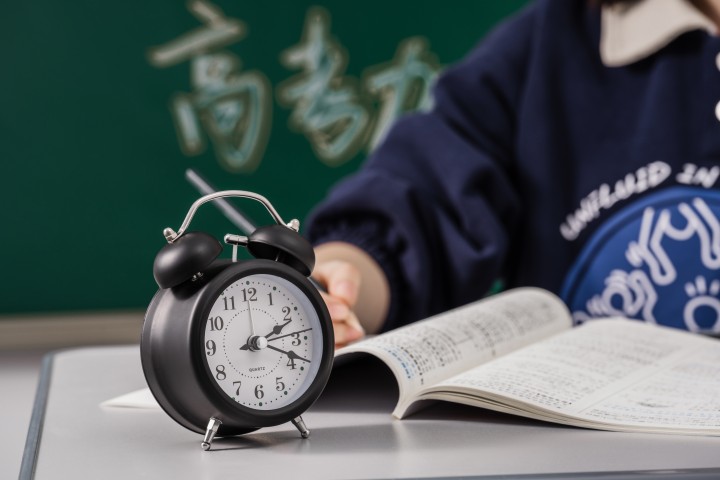 黑色闹钟和正在学习的学生高清图版权图片下载 黑色闹钟和正在学习的学生高清图版权图片下载