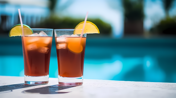 清凉夏日泳池旁的两杯饮品摄影图片