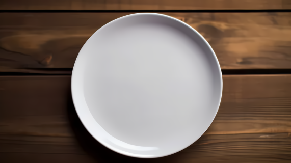 木质桌面上的白色干净盘子摄影图片