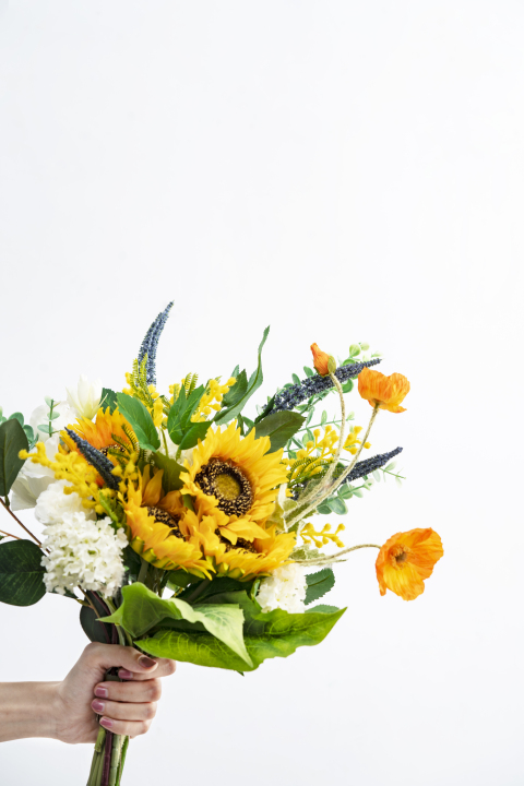 手持橙黄色向日葵和虞美人鲜花竖图版权图片下载