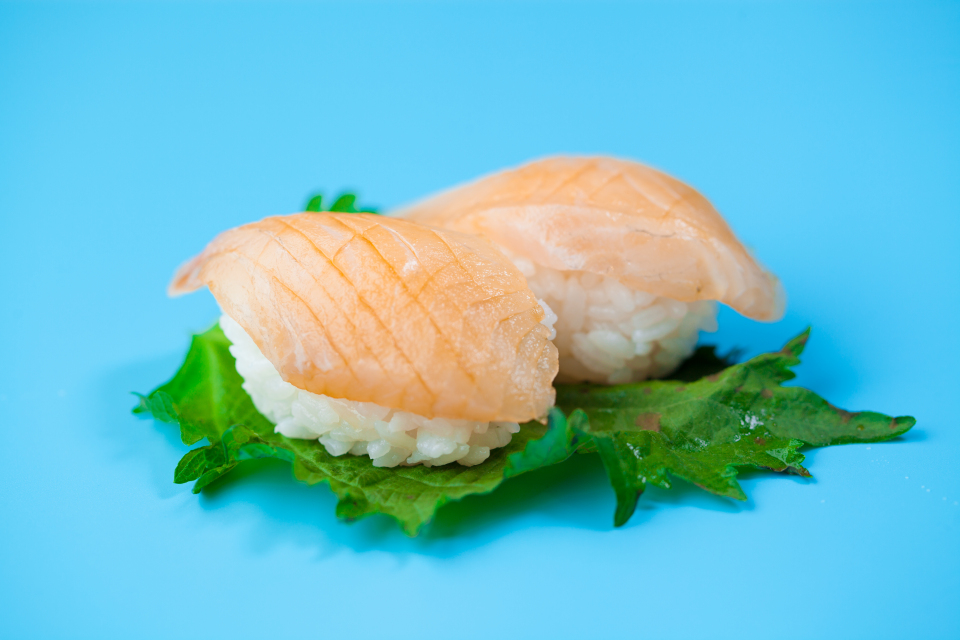 手握三文鱼鲜美日料寿司卷