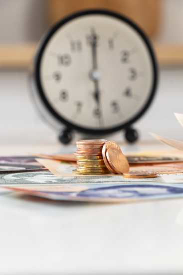 闹钟前堆积金币近景图