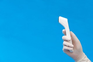 医疗工作者手拿测温仪侧面高清图