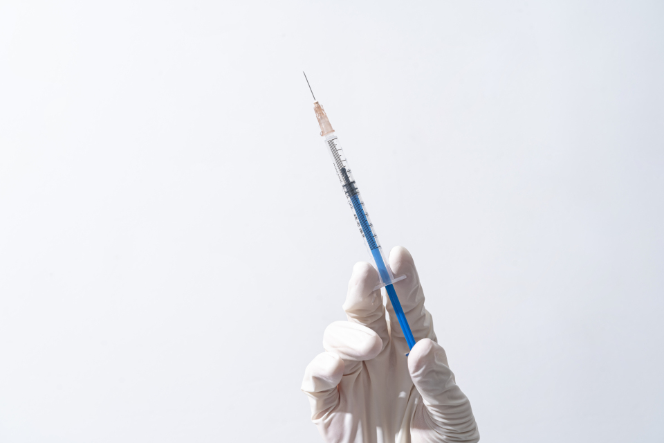 右手拿医用针管注射器实拍图