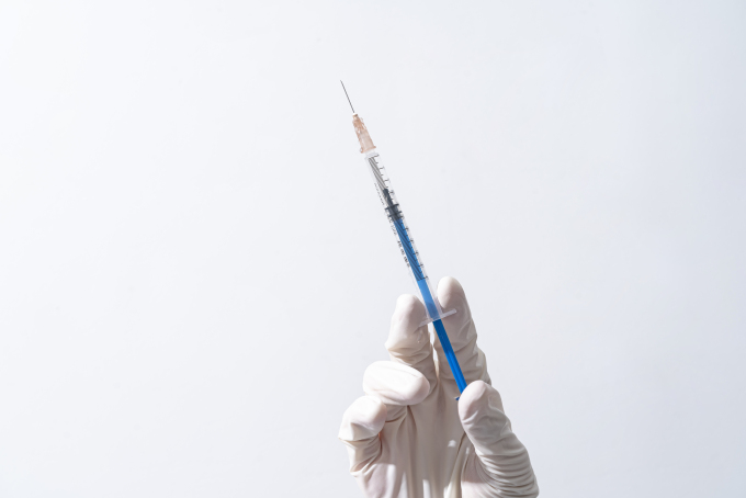 右手拿医用针管注射器实拍图