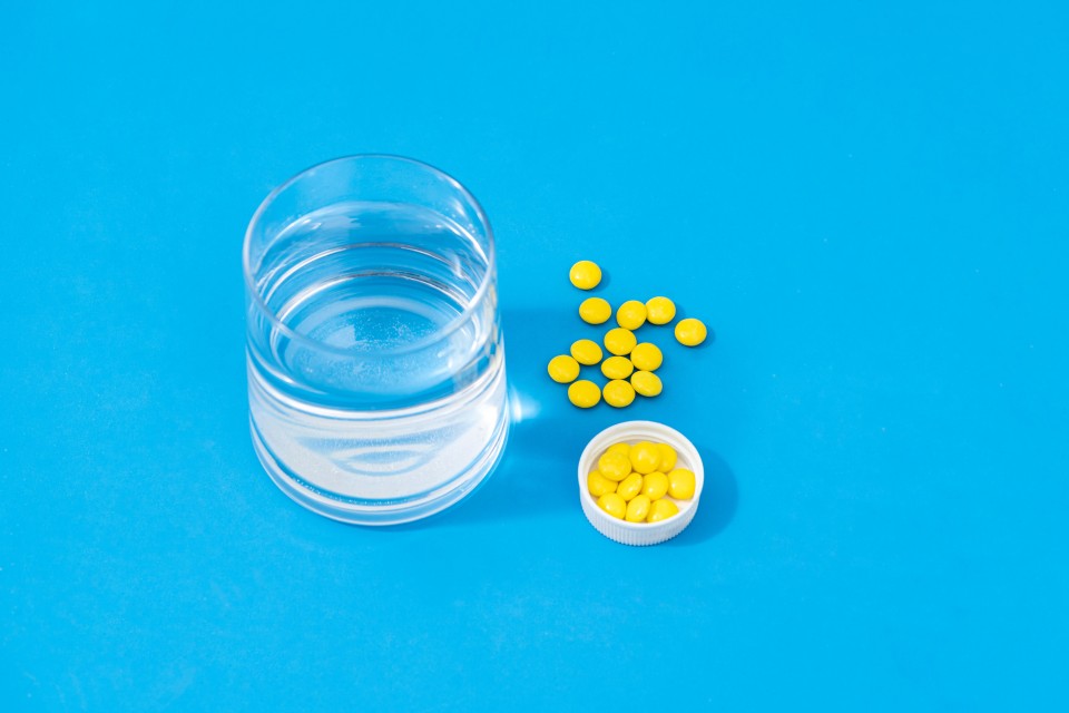 黄色药片一杯水俯拍高清图