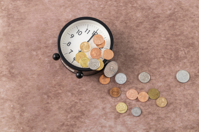 桌面闹钟散落硬币金融高清图