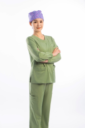 绿色手术服女医生双手环抱侧身站立高清图