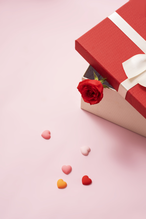 玫瑰礼品盒旁散落巧克力实拍图版权图片下载