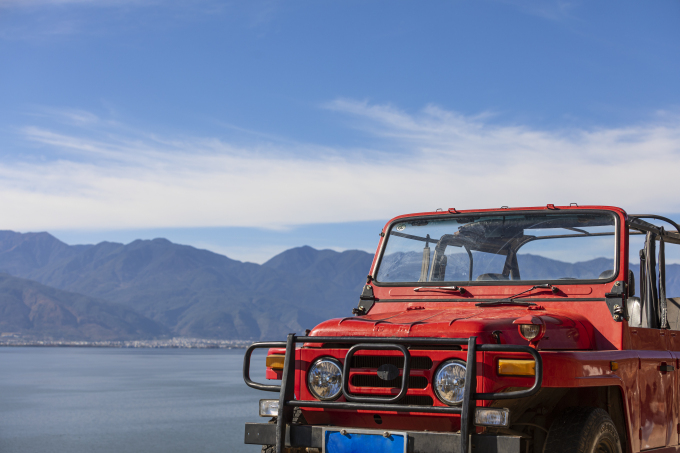 红色越野车湖边休闲度假高清图