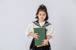 漂亮女孩怀抱图书乖巧实拍图