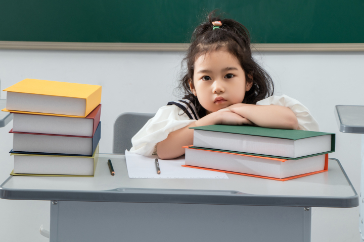 趴在书本上的小女孩高清图版权图片下载