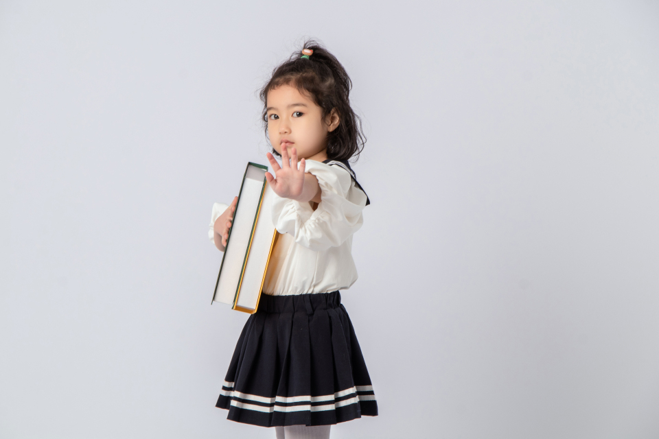 可爱俏皮小学生抱图书实拍图