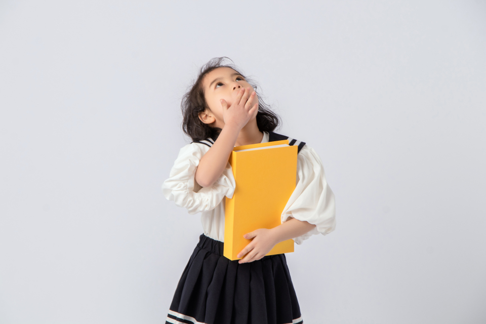 捂嘴大笑可爱小姑娘上学实拍图