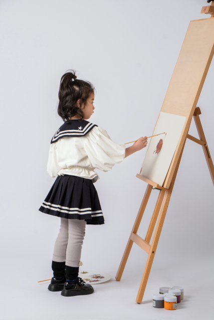 在画板上画画的可爱女孩图