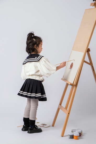 在画板上画画的可爱女孩图