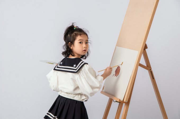 画板前努力画画的可爱女孩图