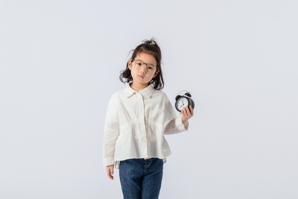 手拿黑色闹钟的小模特实拍图