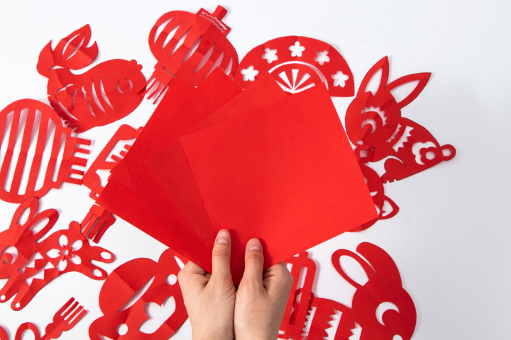手拿春节喜庆红色彩纸剪纸材料实拍图版权图片下载
