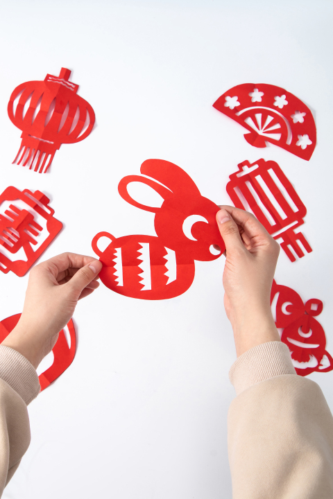 手拿可爱兔子图案剪纸中国传统实拍图版权图片下载