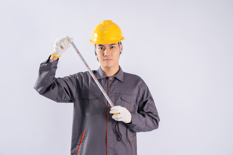 工人手拿测量工具卷尺实拍图