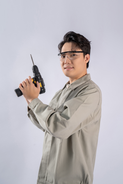 手拿电动螺丝刀工人实拍图