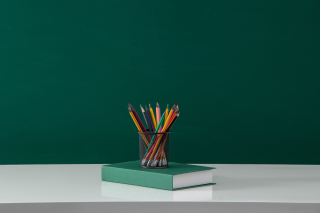 装满的笔筒放在书上实拍图