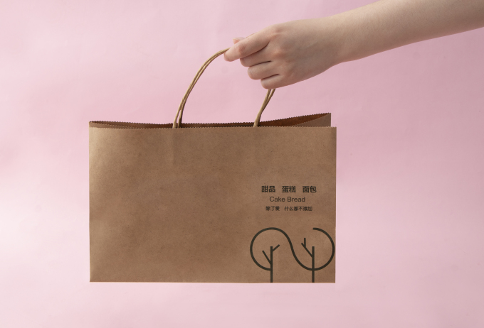 手拿土黄色面包礼品袋高清图