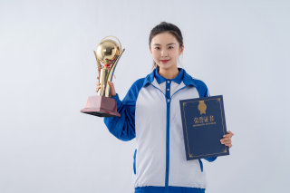 获得荣誉证书和奖杯的女中学生高清图