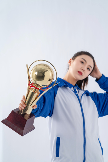 手托脑袋拿奖杯拍照的女生高清图