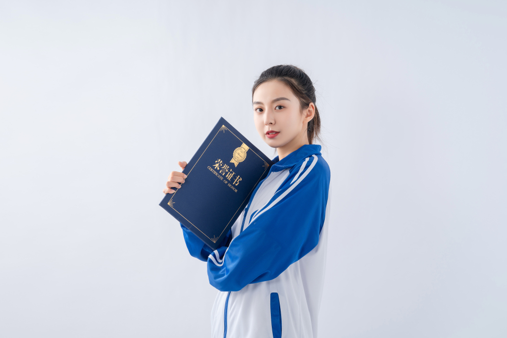 抱着荣誉证书拍照的女生高清图版权图片下载