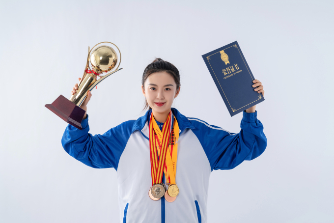 手拿奖杯荣誉证书的运动员高清图