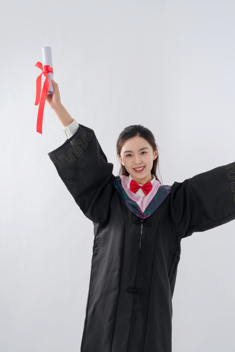 欢快的手持毕业证的女学生高清图版权图片下载
