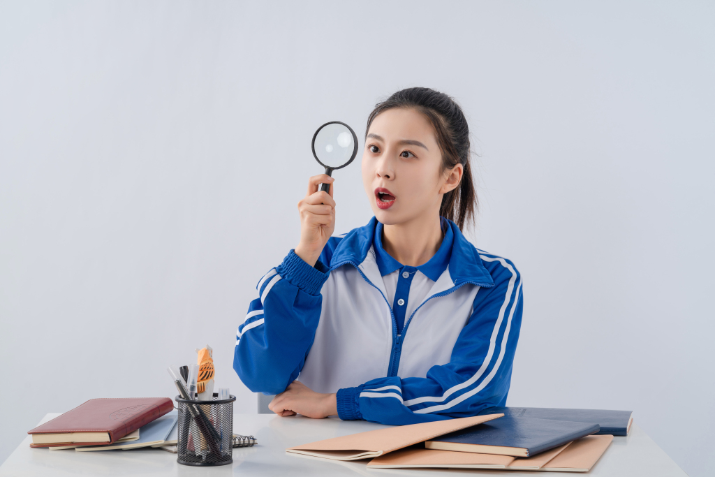 通过放大镜看东西的女学生高清图版权图片下载