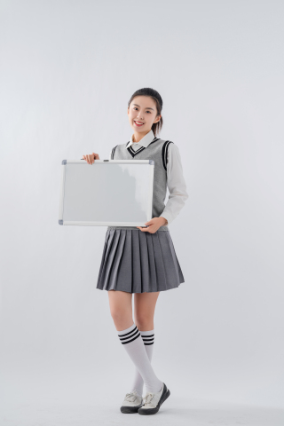 穿校服拿白板拍照的女学生高清图