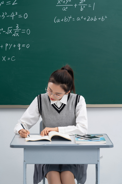 课桌前认真学习的女学生版权图片下载