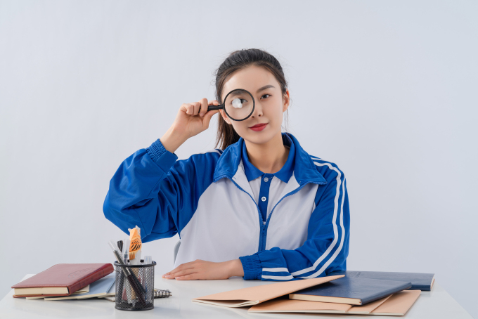 课堂上玩放大镜的女生高清图