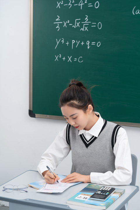 低头认真答题的女学生版权图片下载