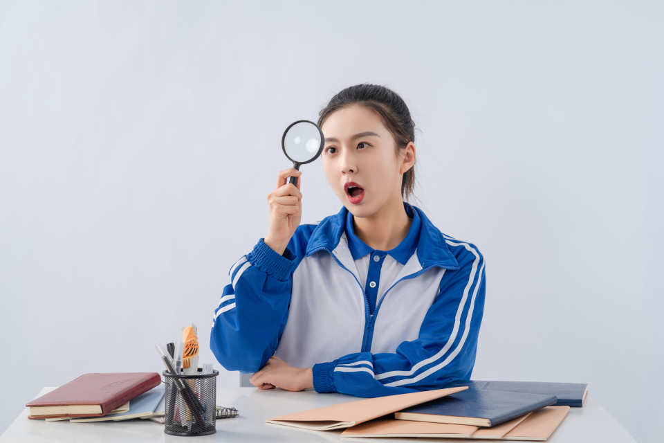 看着放大镜惊讶的女生高清图