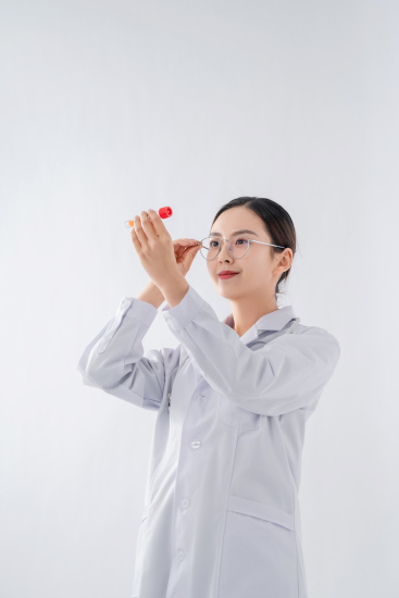 手拿试管抬头观察的女医生实拍图