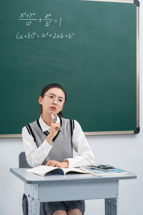 课桌前认真听讲的女学生高清图版权图片下载