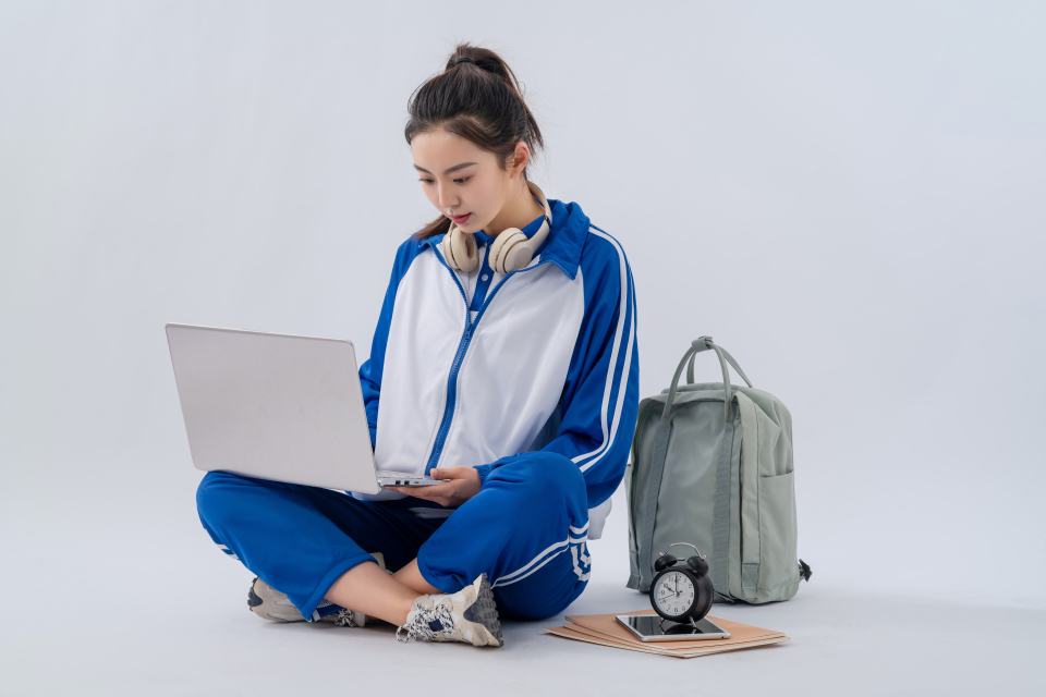 笔记本放膝盖检查作业的学生实拍图